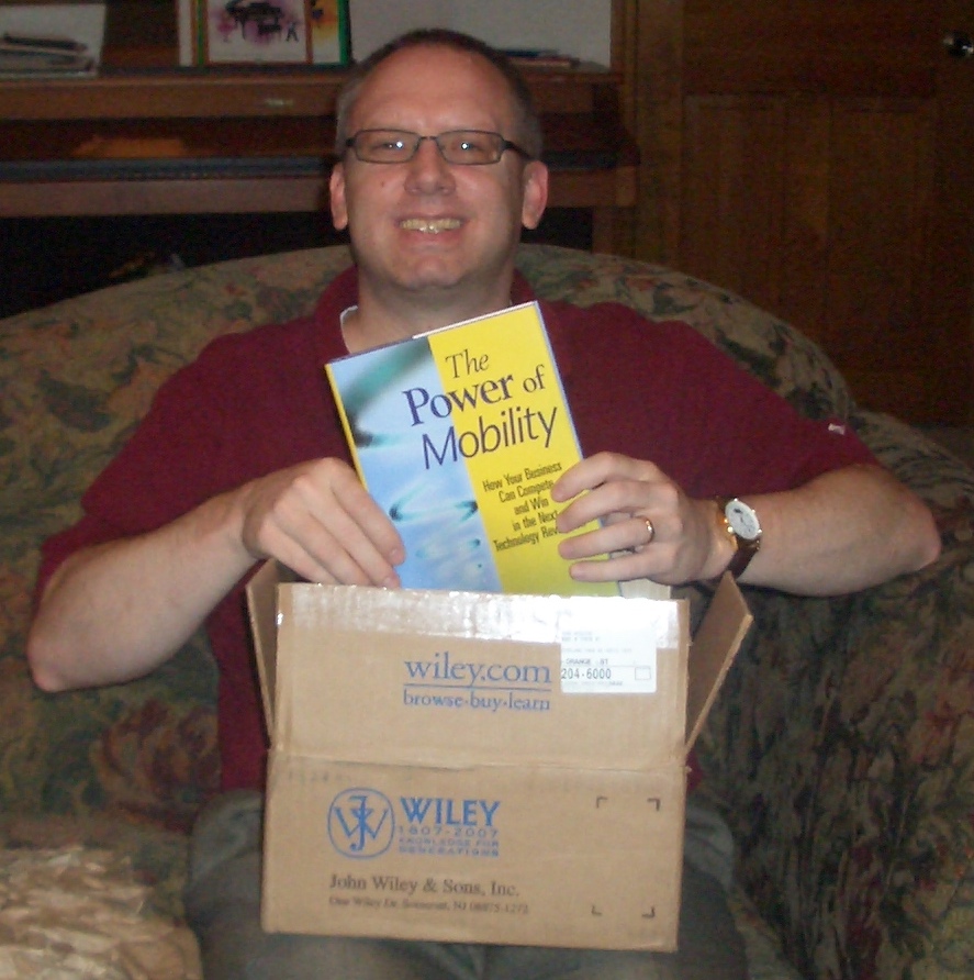 Russ unboxing author copies of his The Power of Mobility book.